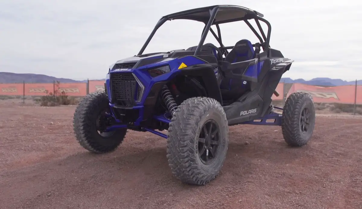 A Polaris RZR XP Turbo S is parked on a desert surface.