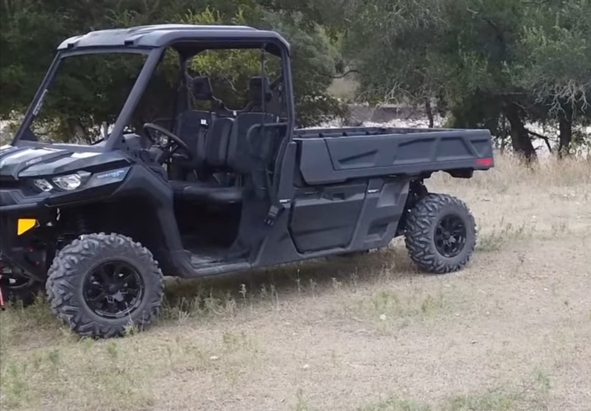 A Can-am defender Pro XT is parked on a dry grass field.