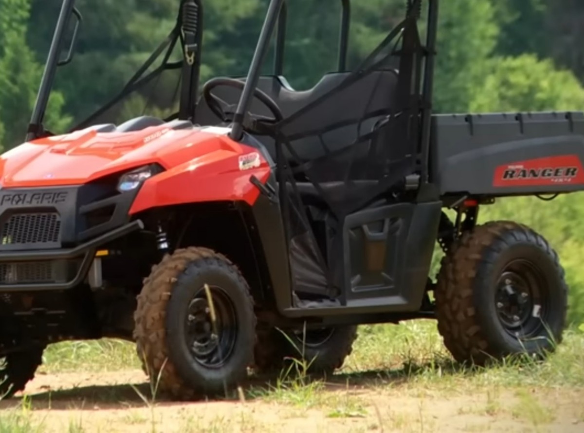 A Polaris Ranger 500 is parked in a green field.