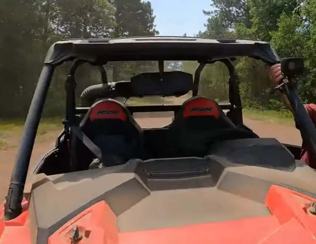 A Polaris UTV is parked on a dirt surface.