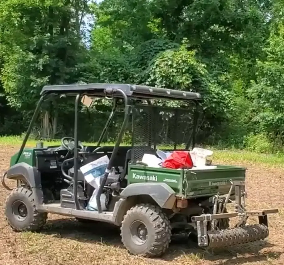 Driving my UTV with enthusiasm, I utilized a cultivator to prepare the soil for my food plot, ensuring a bountiful harvest for the local fauna.