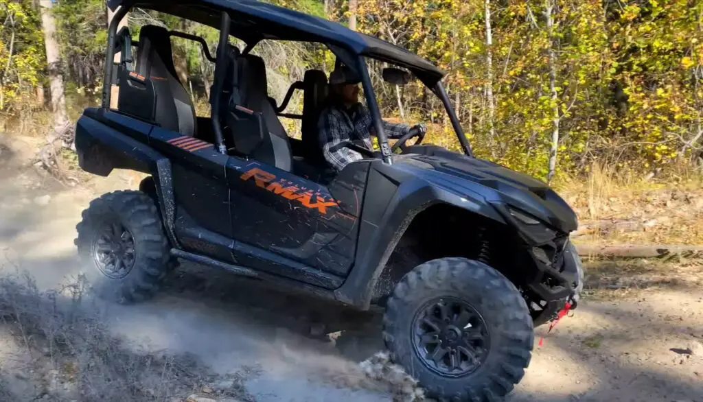 A Yamaha RMAX4 1000 is being driven through a dirt jungle terrain.