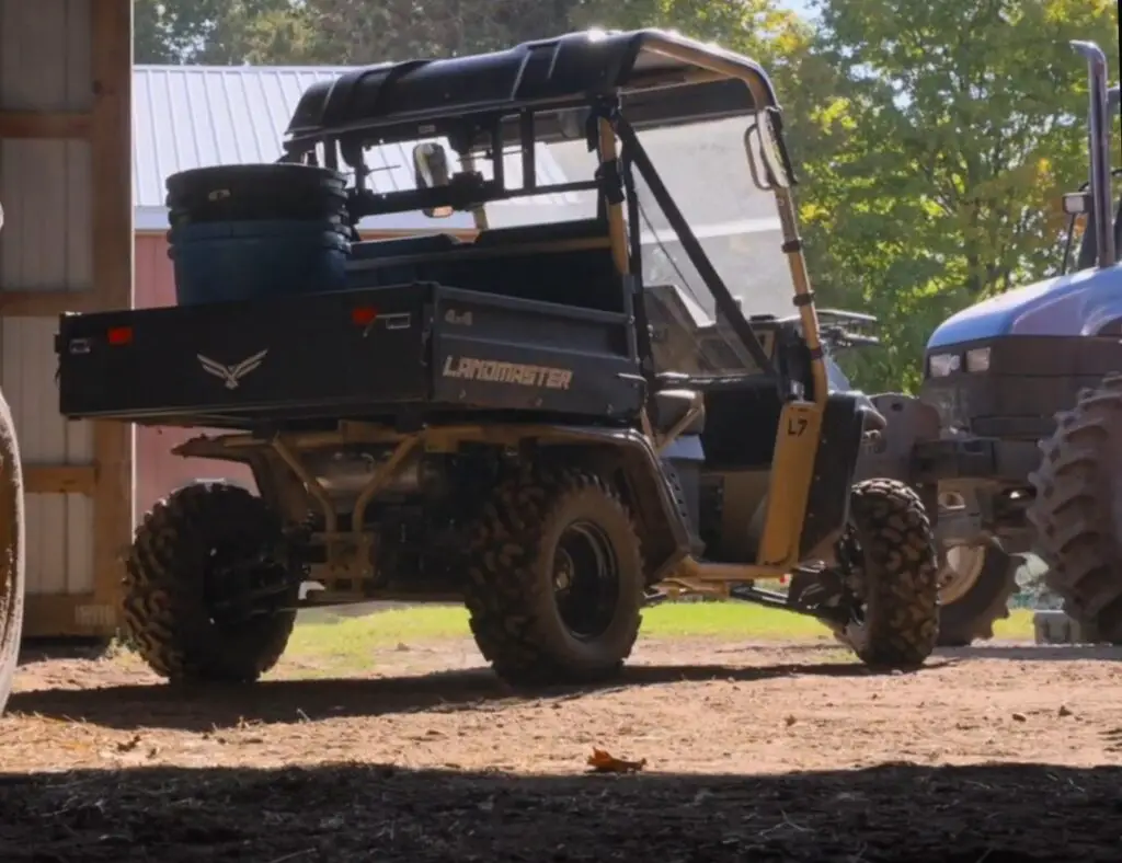 An American landmaster UTV is parked in a farm.