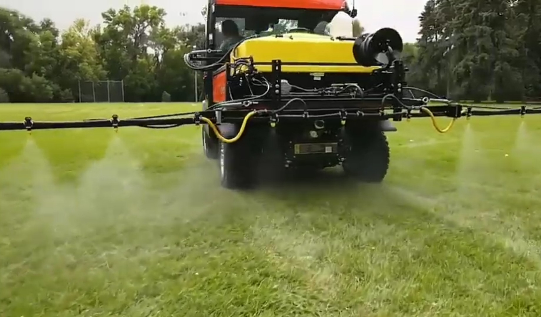 A Kubota UTV is spraying on a green field.