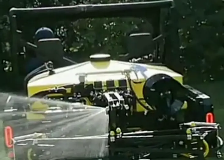 A can-am UTV is spraying on a green field with UTV sprayer.