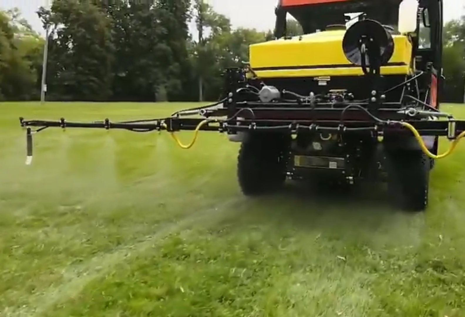 A Kubota UTV is spraying on a green field with FIMCO 65 Gallon UTV sprayer.