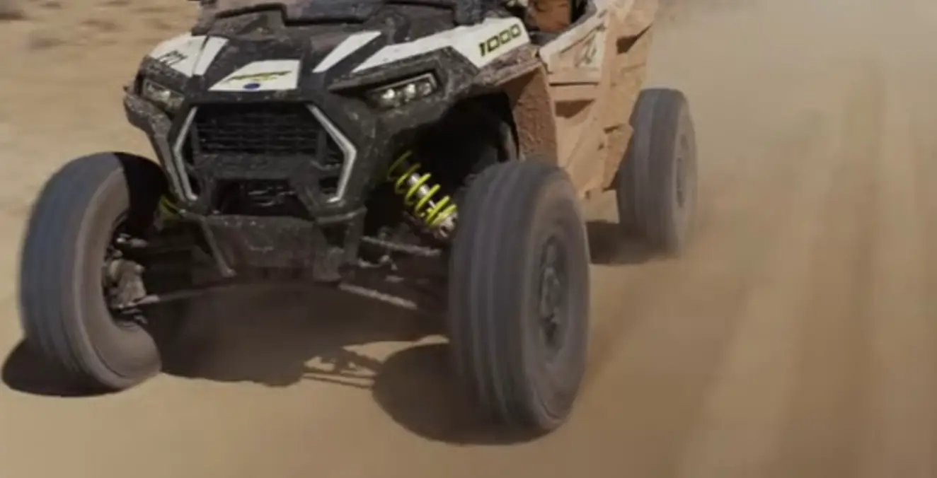 A Polaris RZR 1000 is being driven through a dirt road in utah.