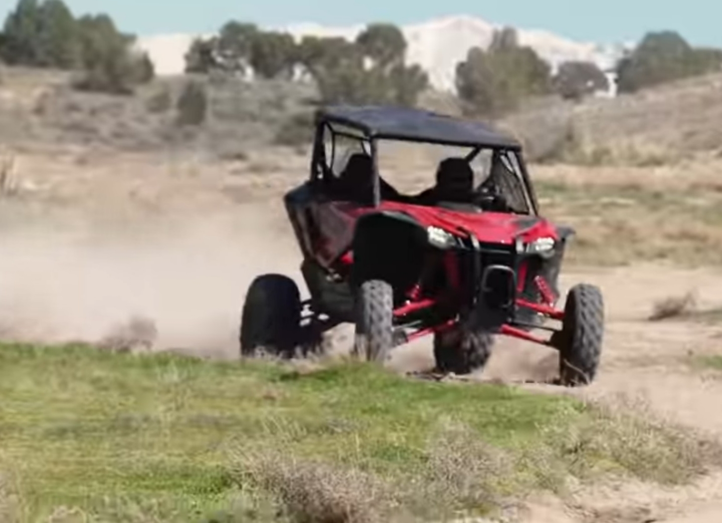 A Honda Talon UTV is being driven through a dirt road.