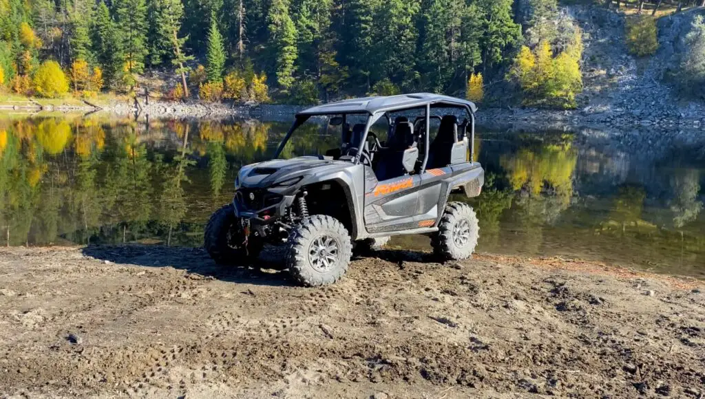 A Yamaha RMAX4 1000 is parked in front of a lake.