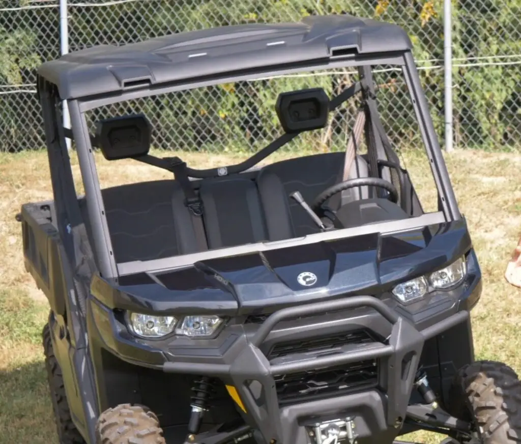 A Can-am defender pro XT is parked on a grassy field.