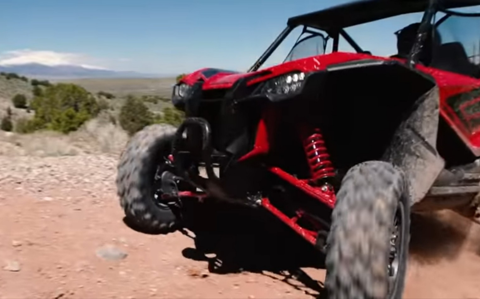 A Honda Talon 1000R is being driven through a rocky mountain road.