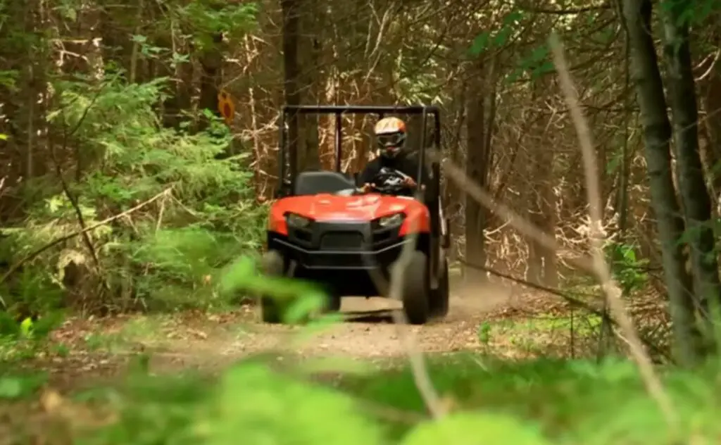 A Polaris Ranger 500 is being driven through a dirt jungle terrain.