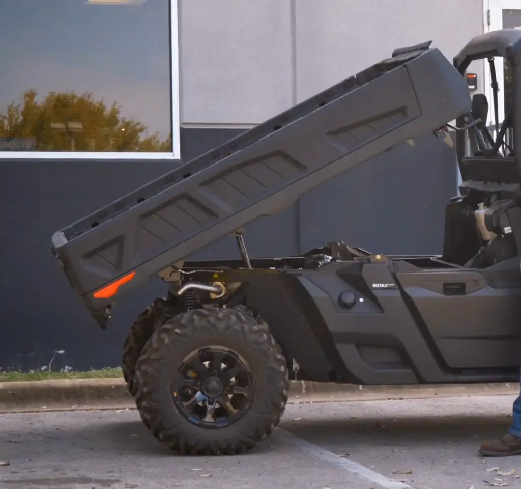 A Can-am defender pro XT is parked in front of a wall.