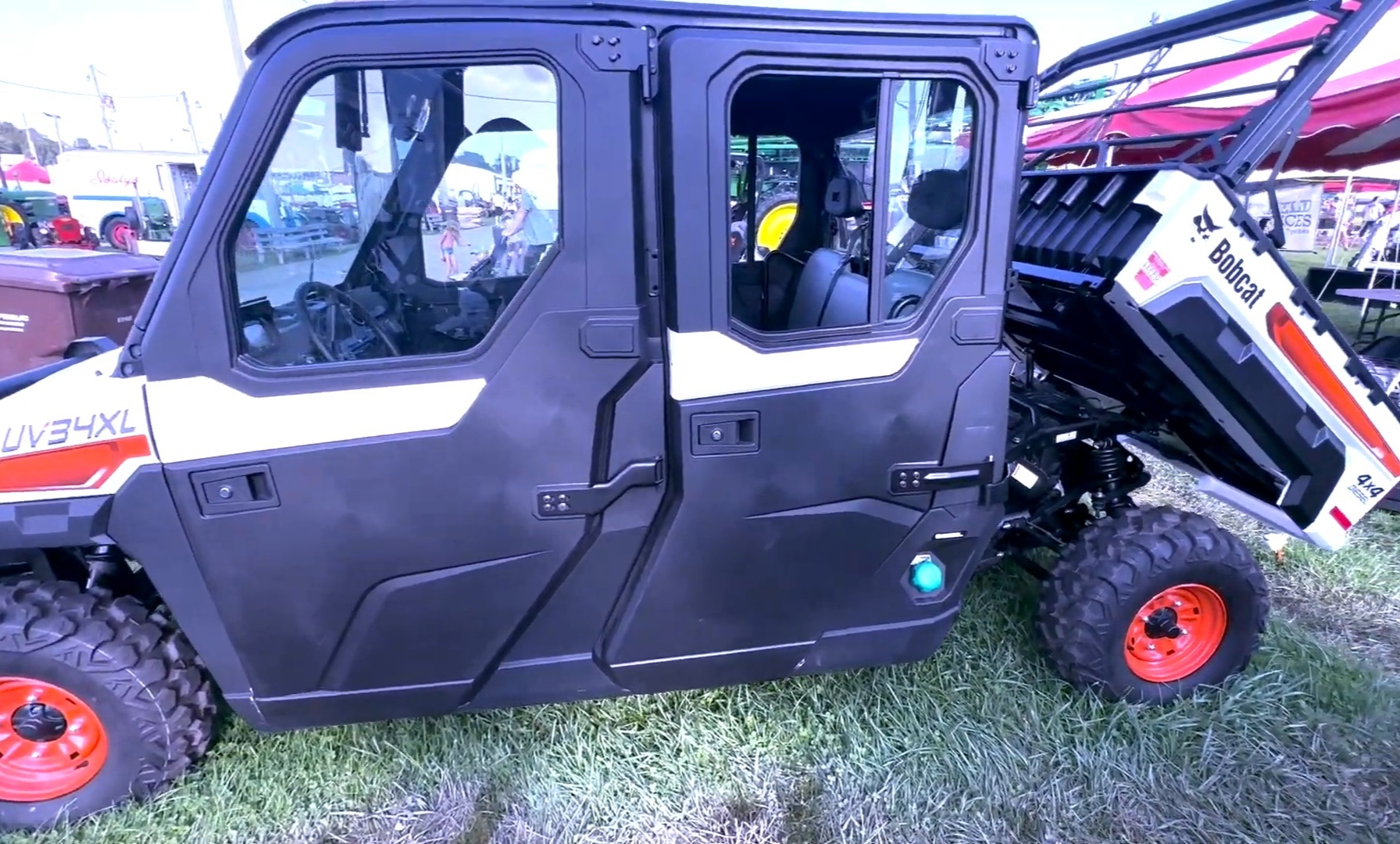 A Bobcat UV34XL with dump bed is parked in a parking lot.