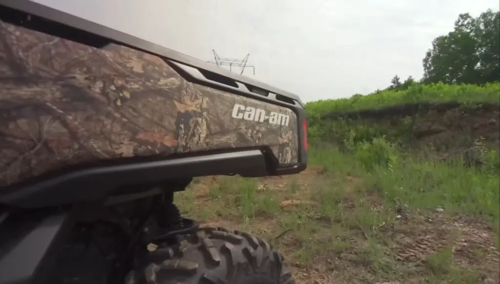 A Can-am defender HD10 is parked on a grassy field.