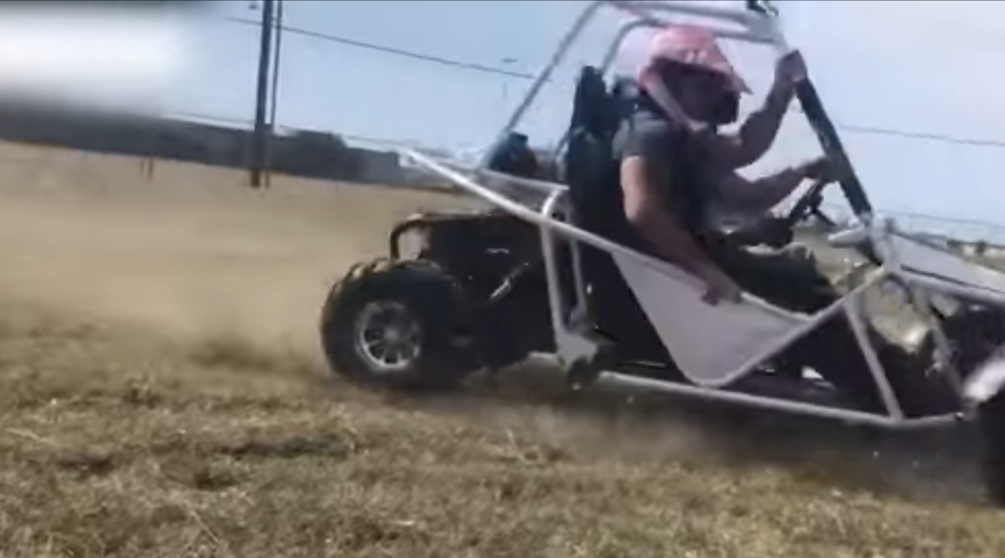 A kid is driving a child UTV through a green field.