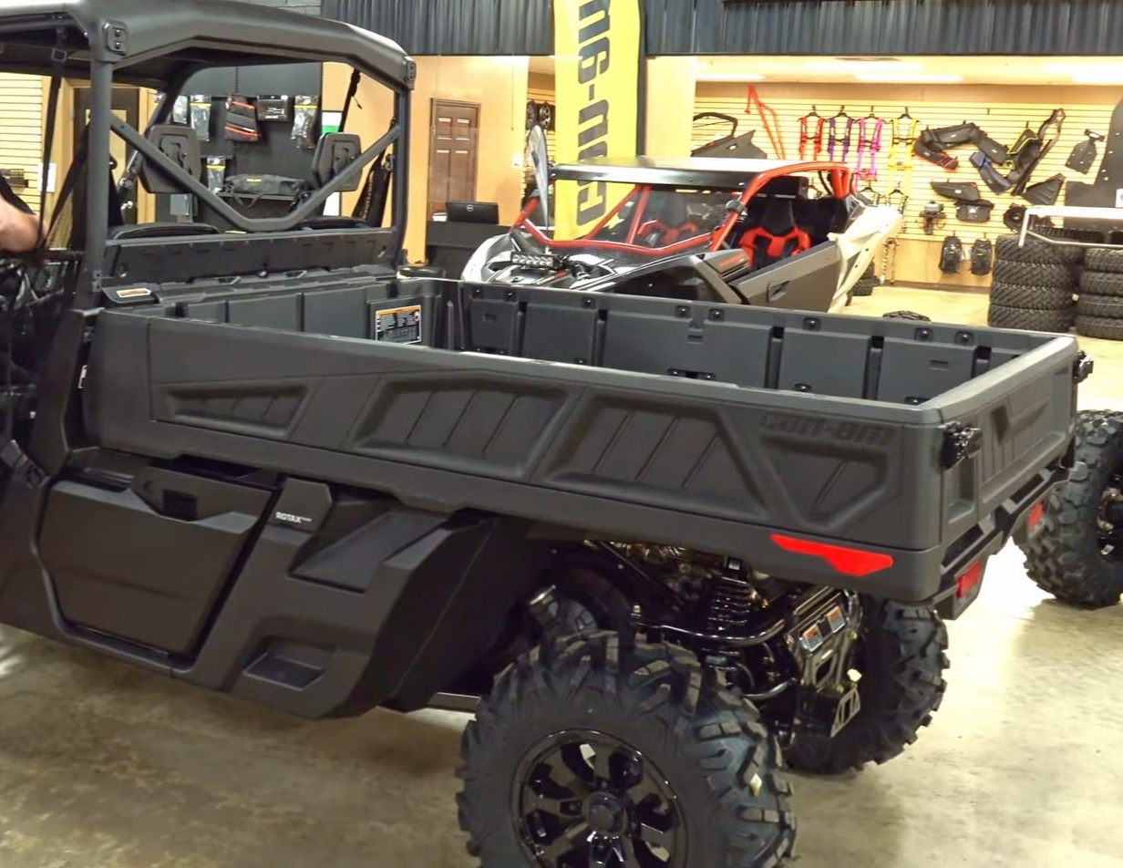 Can-Am Defender Pro XT Flat Bed is parked in a Can-am showroom.