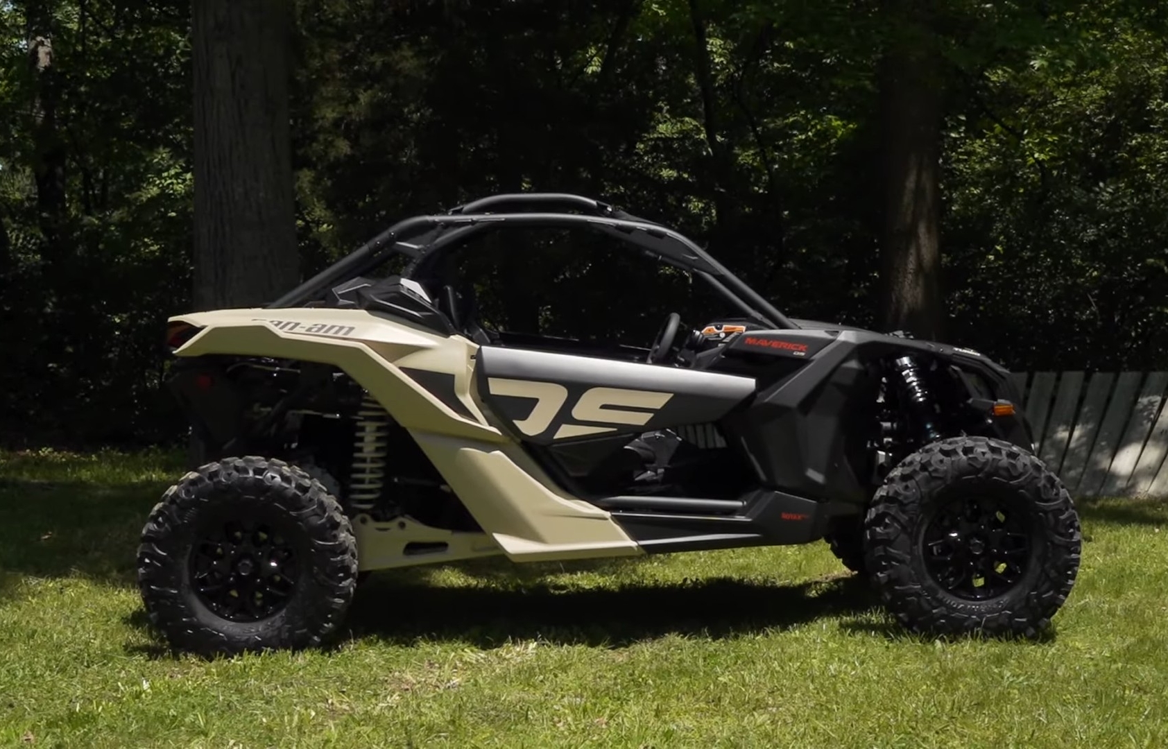 A Can-am Maverick X3 is parked on a grassy field.