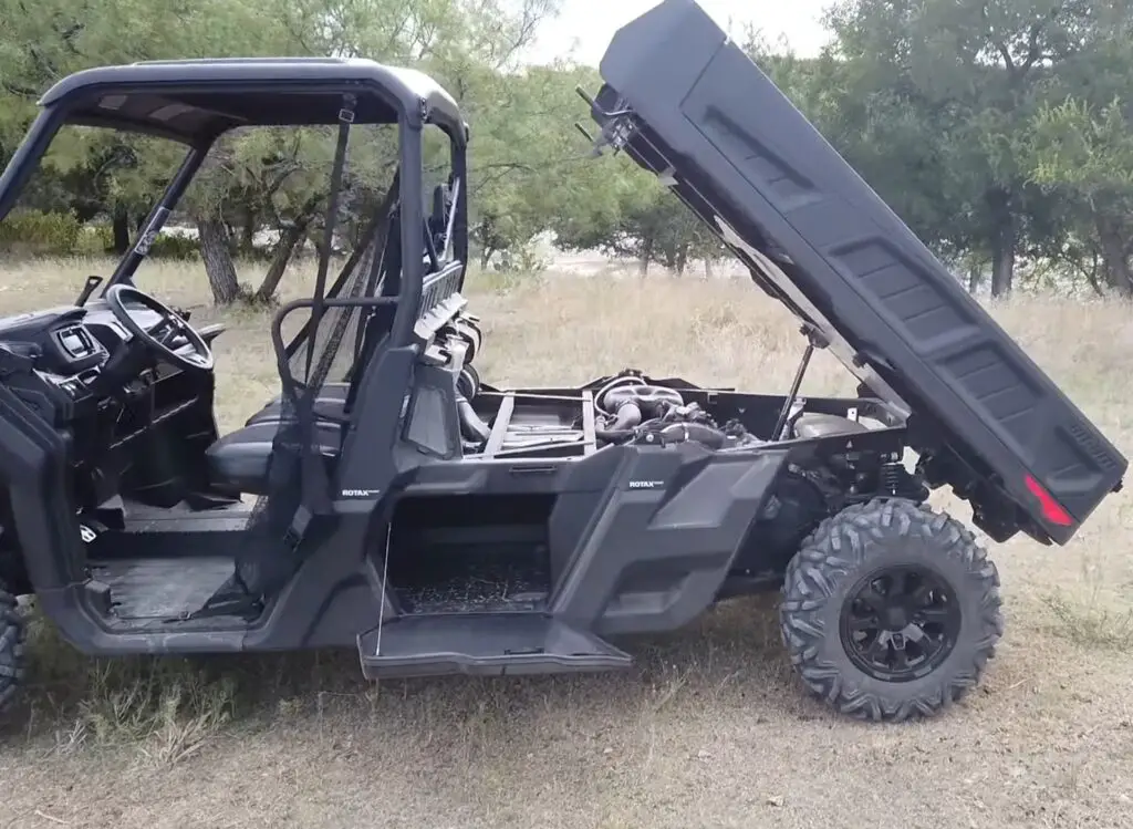 A Can-am defender pro XT is parked in a dry grass field.