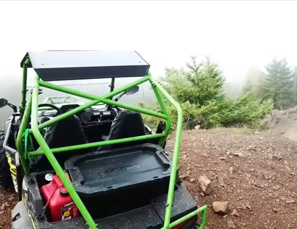 A green child UTV is parked on a gravel surface.