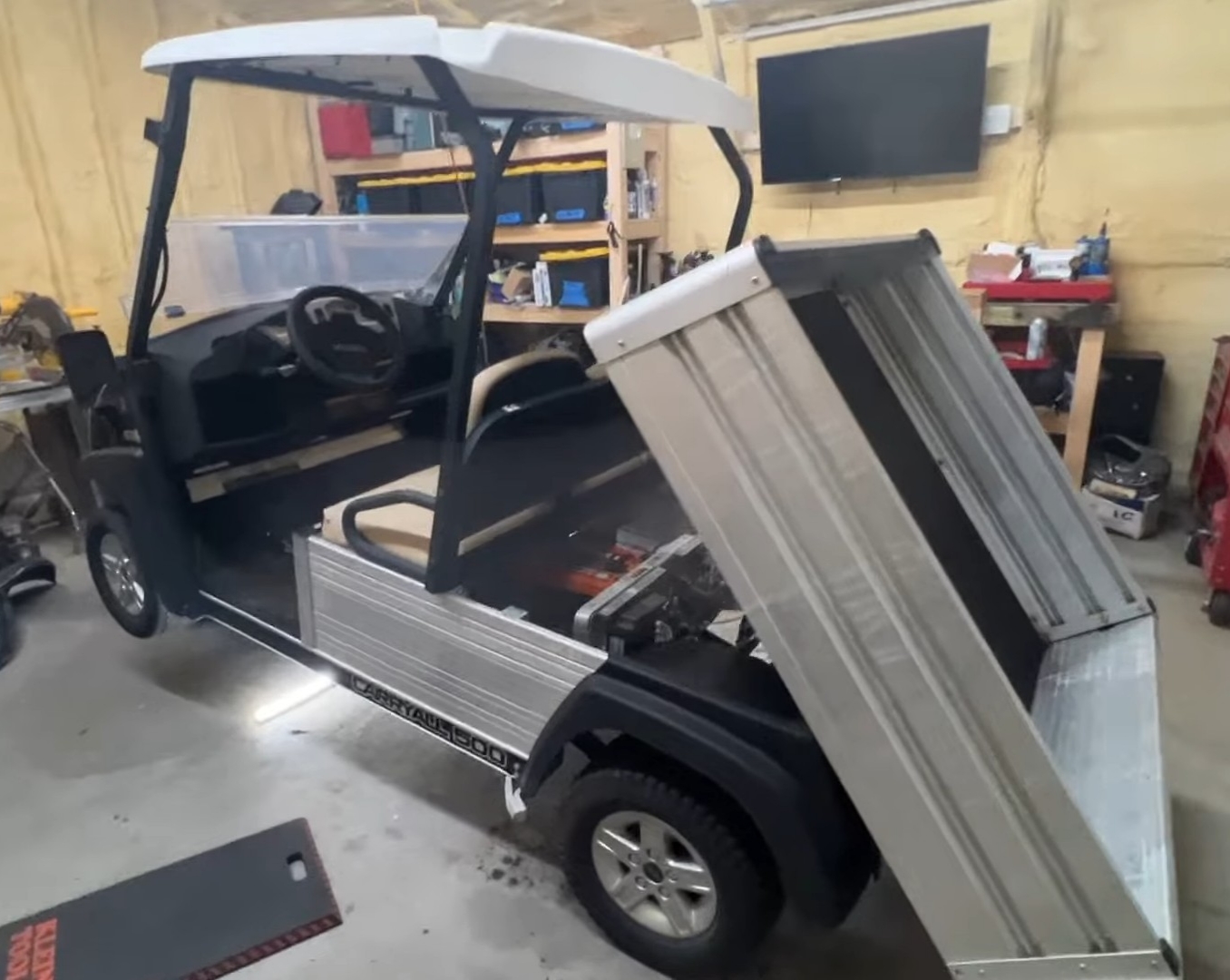 A Club Car Carryall 500 Electric is parked in a garage.