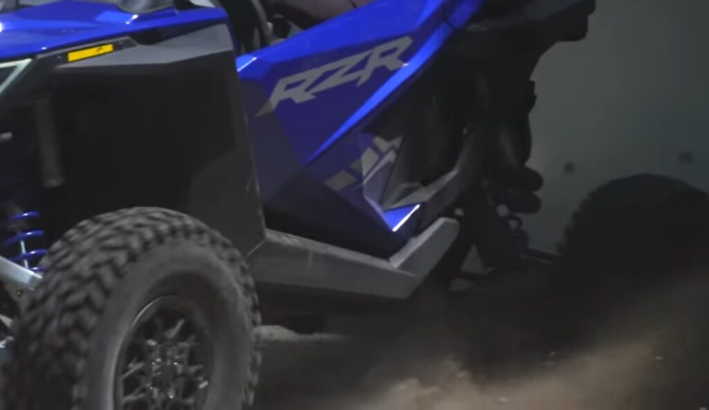 Polaris RZR is on a dusty road.