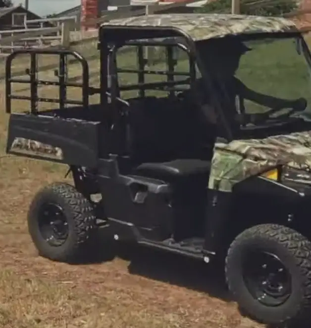 A Polaris Ranger EV is being driven through a dirt road.