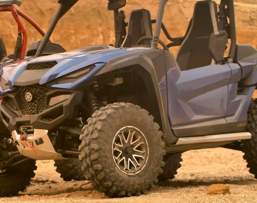 A Yamaha RMAX2 is parked on a dirt surface.