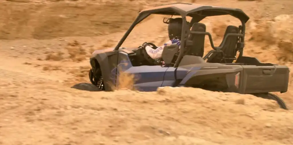 A Yamaha RMAX2 is being driven through a hill road.