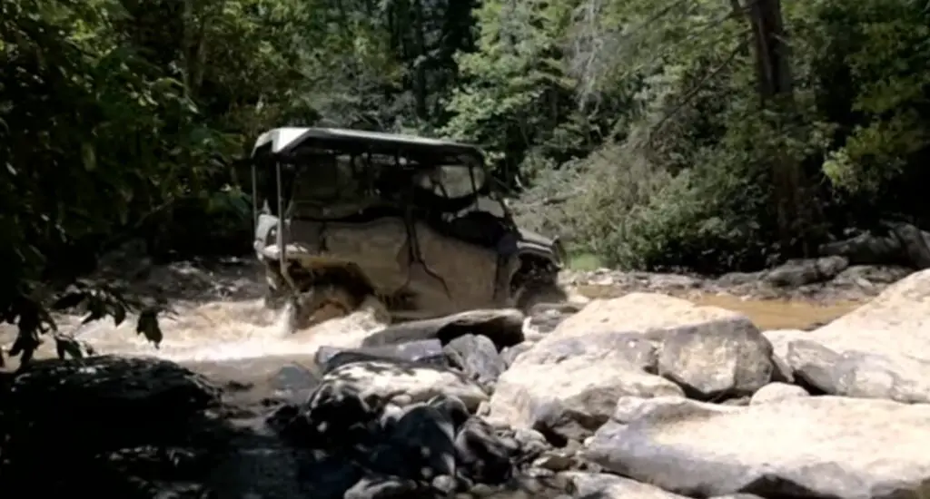 Honda Pioneer 1000 is being driven through a rocky terrain.