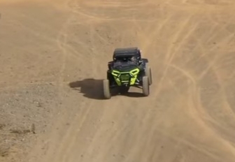 A Polaris turbo is being driven through a dirt road.