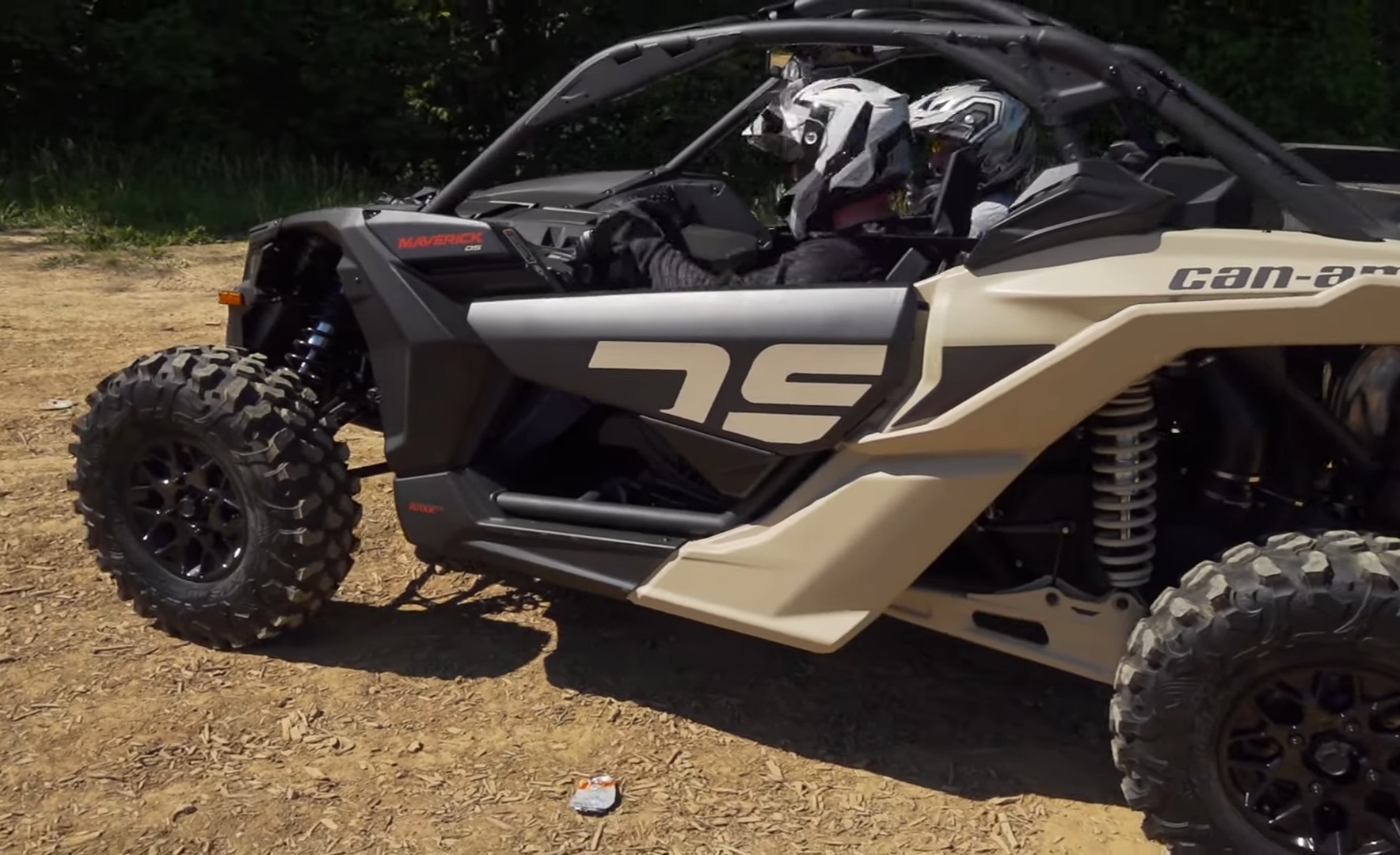 A Can-Am Maverick X3 is parked on a dirt surface.