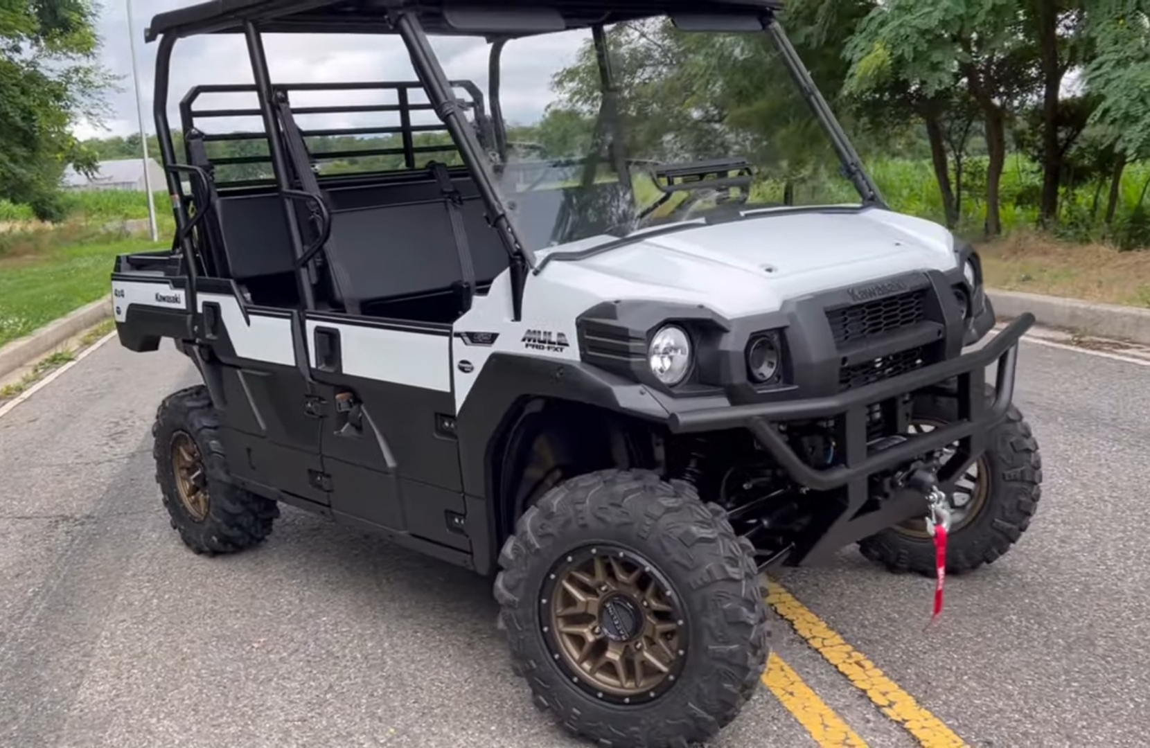 A Kawasaki Pro-FXT EPS is parked on a concrete road.