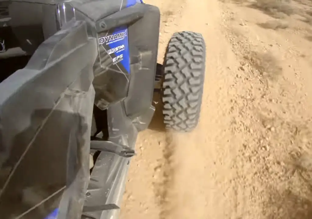 A Polaris RZR XP Turbo S is being driven through a desert road.