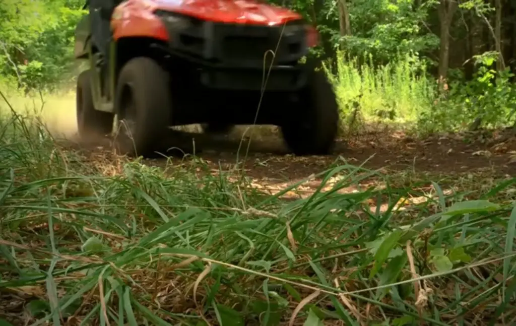 Polaris Ranger 500 is being driven through a grass field.