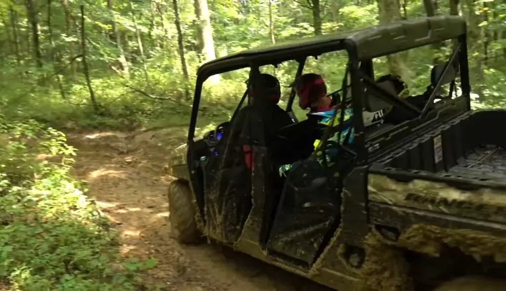 A Polaris Ranger 1000 is being driven through a jungle terrain.