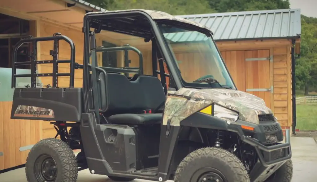 A Polaris Ranger EV is parked in front of a farm house.