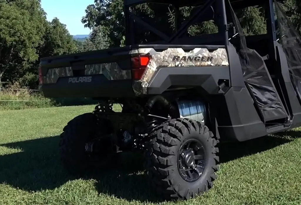 A Polaris Ranger 1000 is parked on a grassy field.