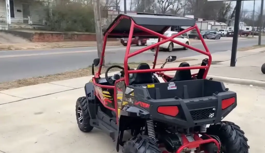 A child UTV is parked in a parking space in front of a road.