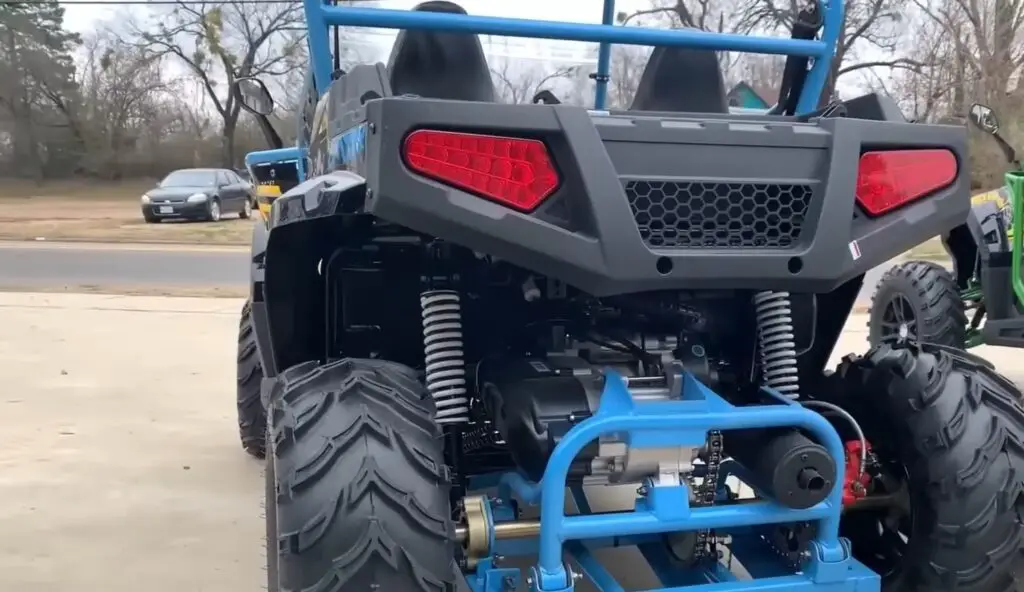 A child UTV is parked on a parking space in front of a road.