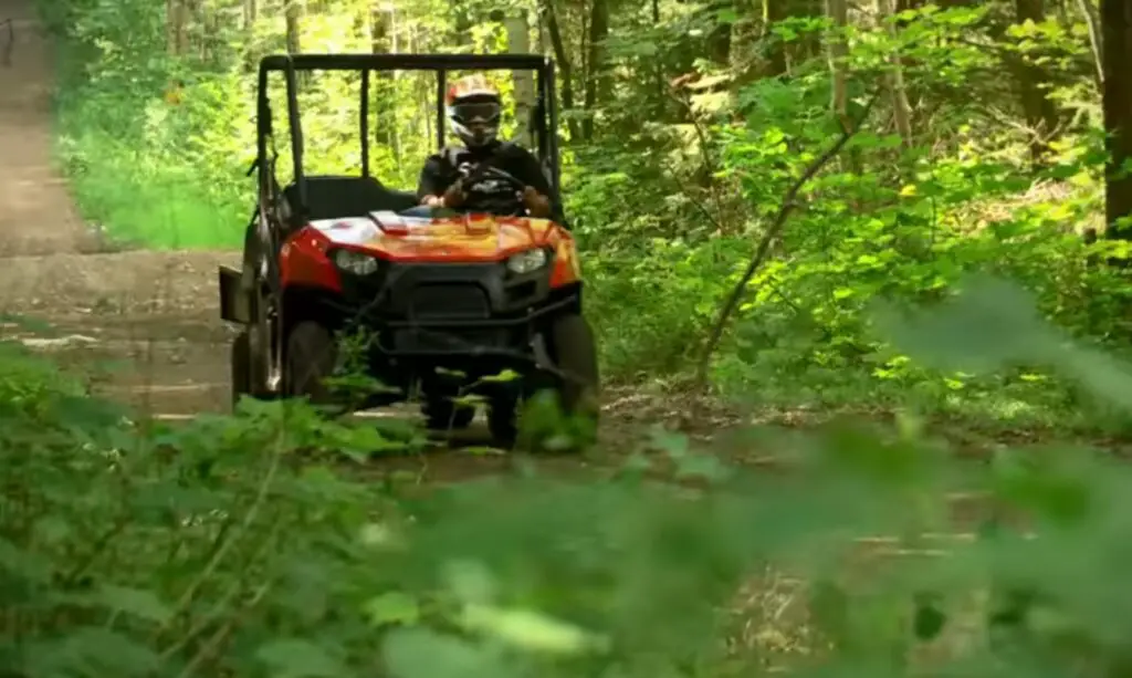 A Polaris Ranger 500 is being driven through a jungle road.