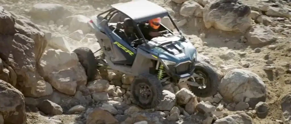 A Polaris UTV is being driven through a rocky terrain.