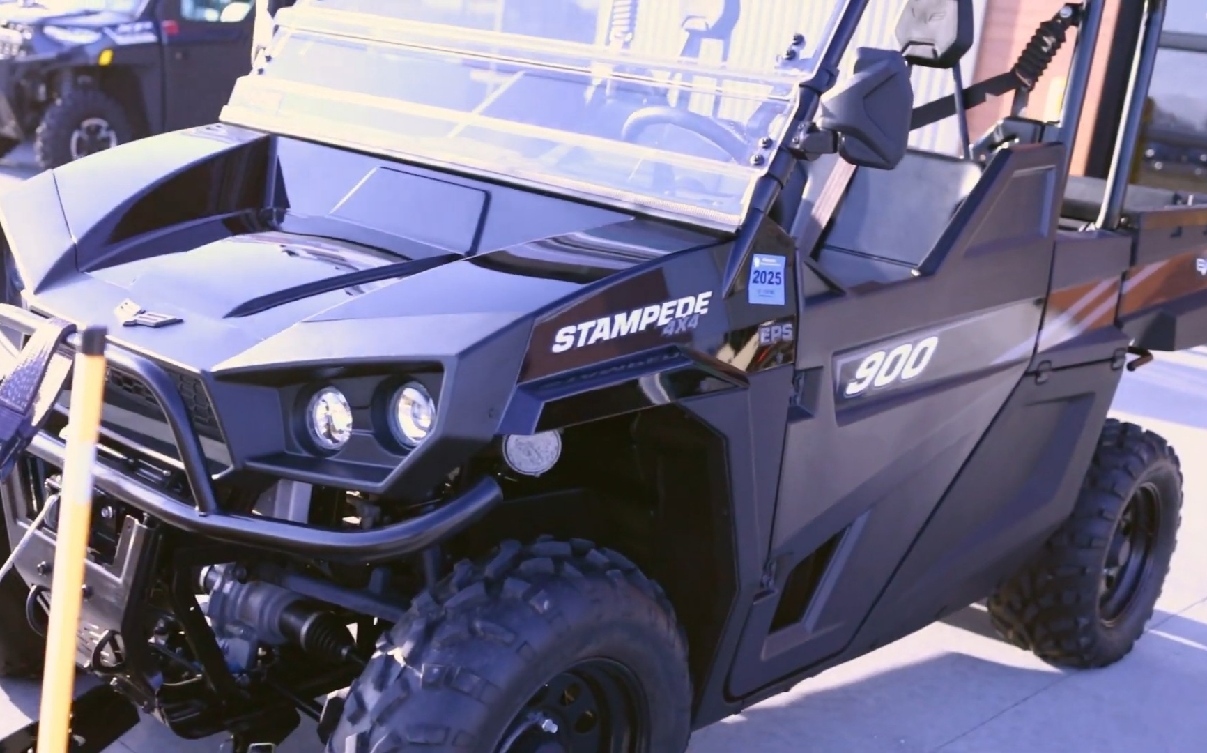 A Textron Stampede EPS is parked outside of a UTV showroom.