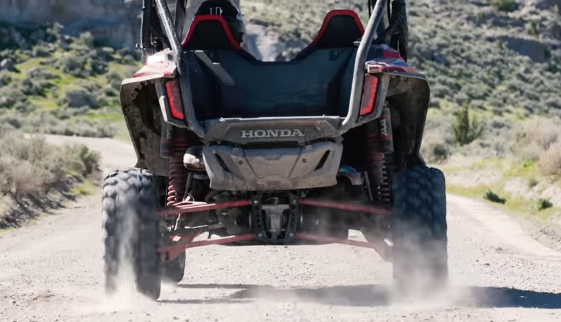 A Honda Talon 1000R is being driven through a dirt road.