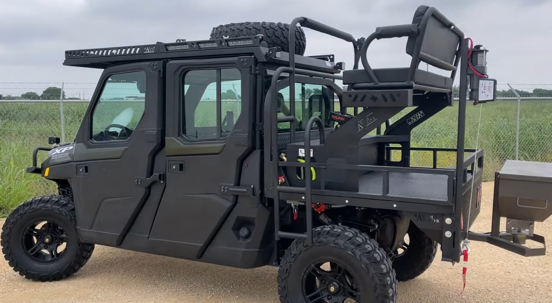 A Polaris Ranger XP 1000 NorthStar is parked in front of a green field with fence.