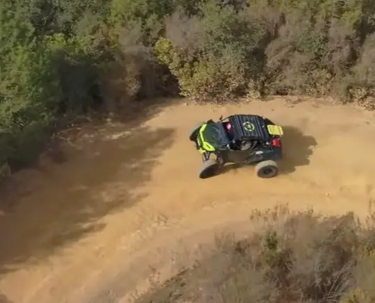 A Polaris UTV is being driven through a dirt road in NY.