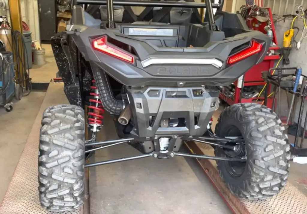 A Polaris RZR is parked in a garage.