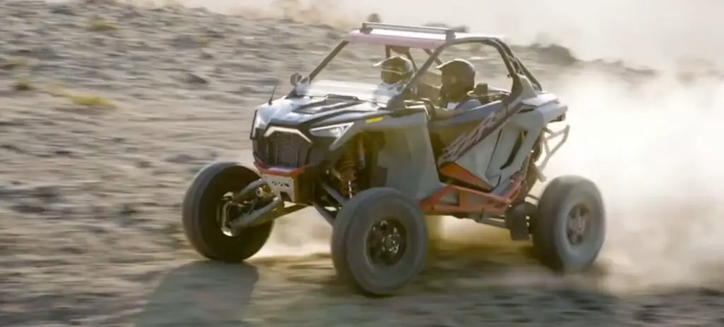 A Polaris UTV is being driven through a dirt field.