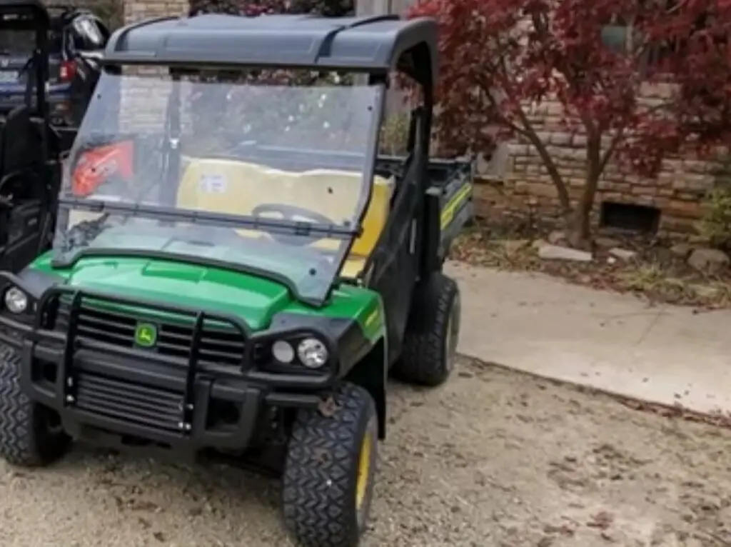 John Deere HPX615E is parked in front of a house.