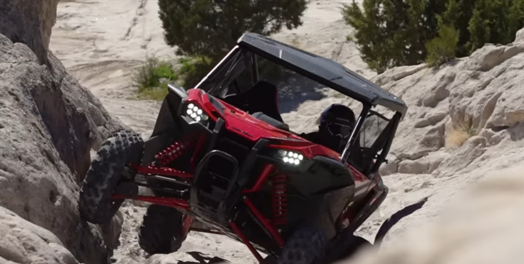 A Honda Talon 1000R is climbing a rocky hill.